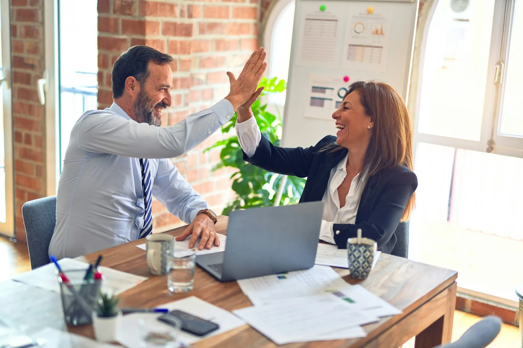 Hiring manager and recruiter celebrating an accepted offer